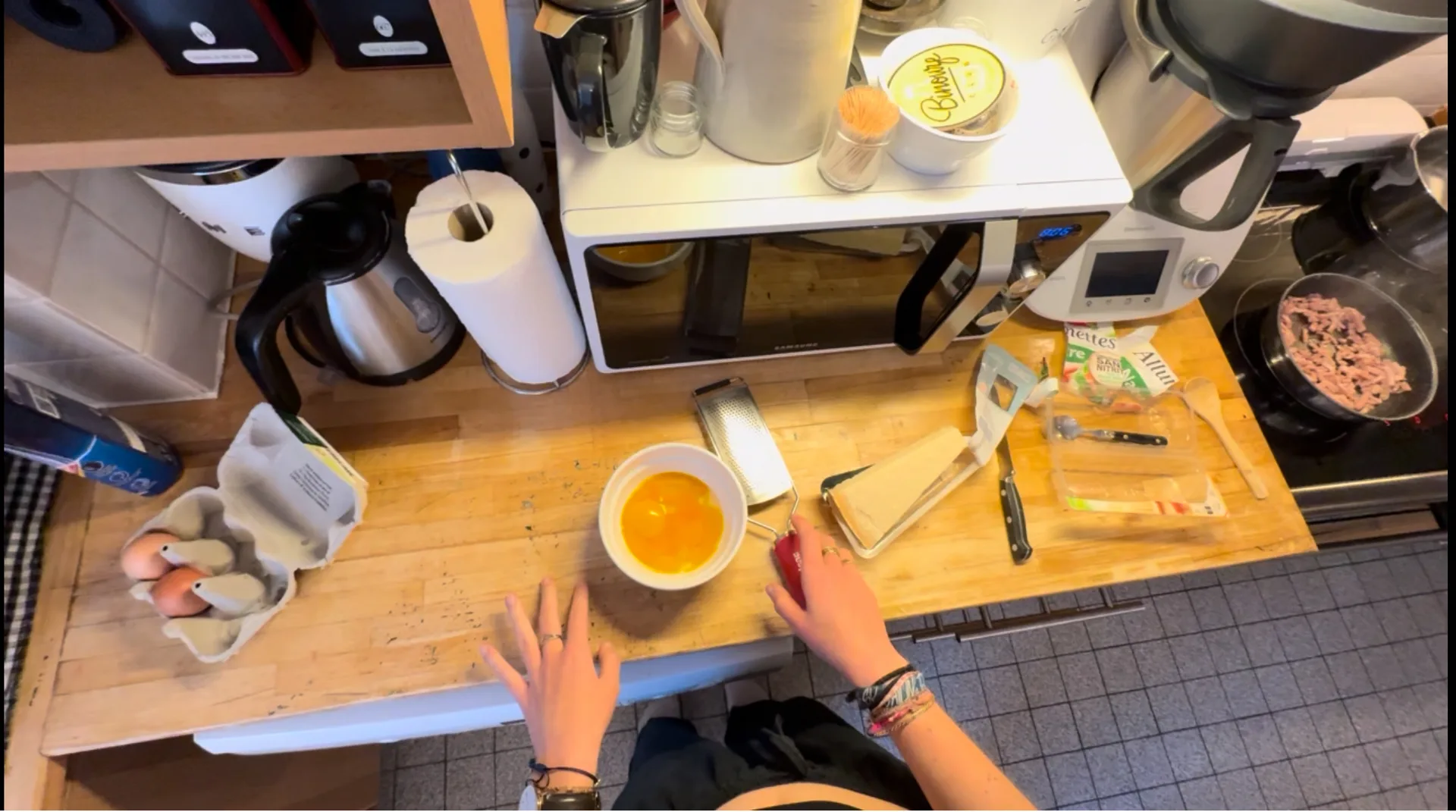 First-person egocentric view of a bimanual cooking task in a home kitchen, captured for manipulation policy training